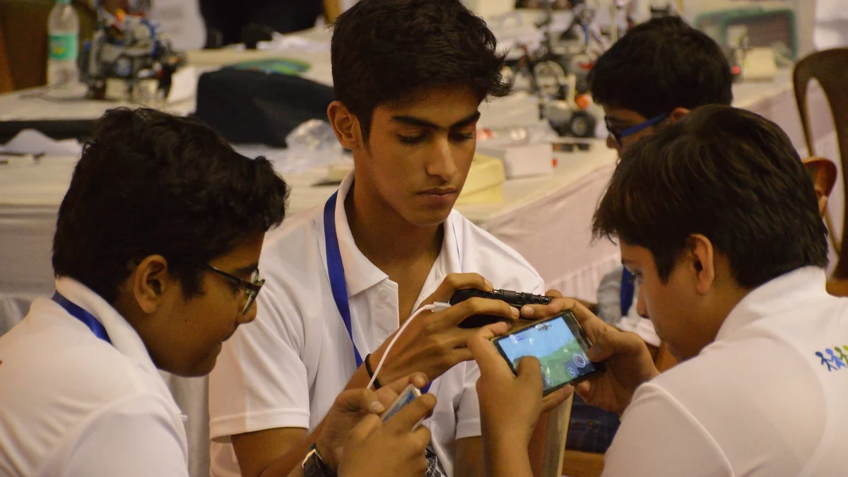Jovens utilizando dispositivos móveis em atividade com jogos